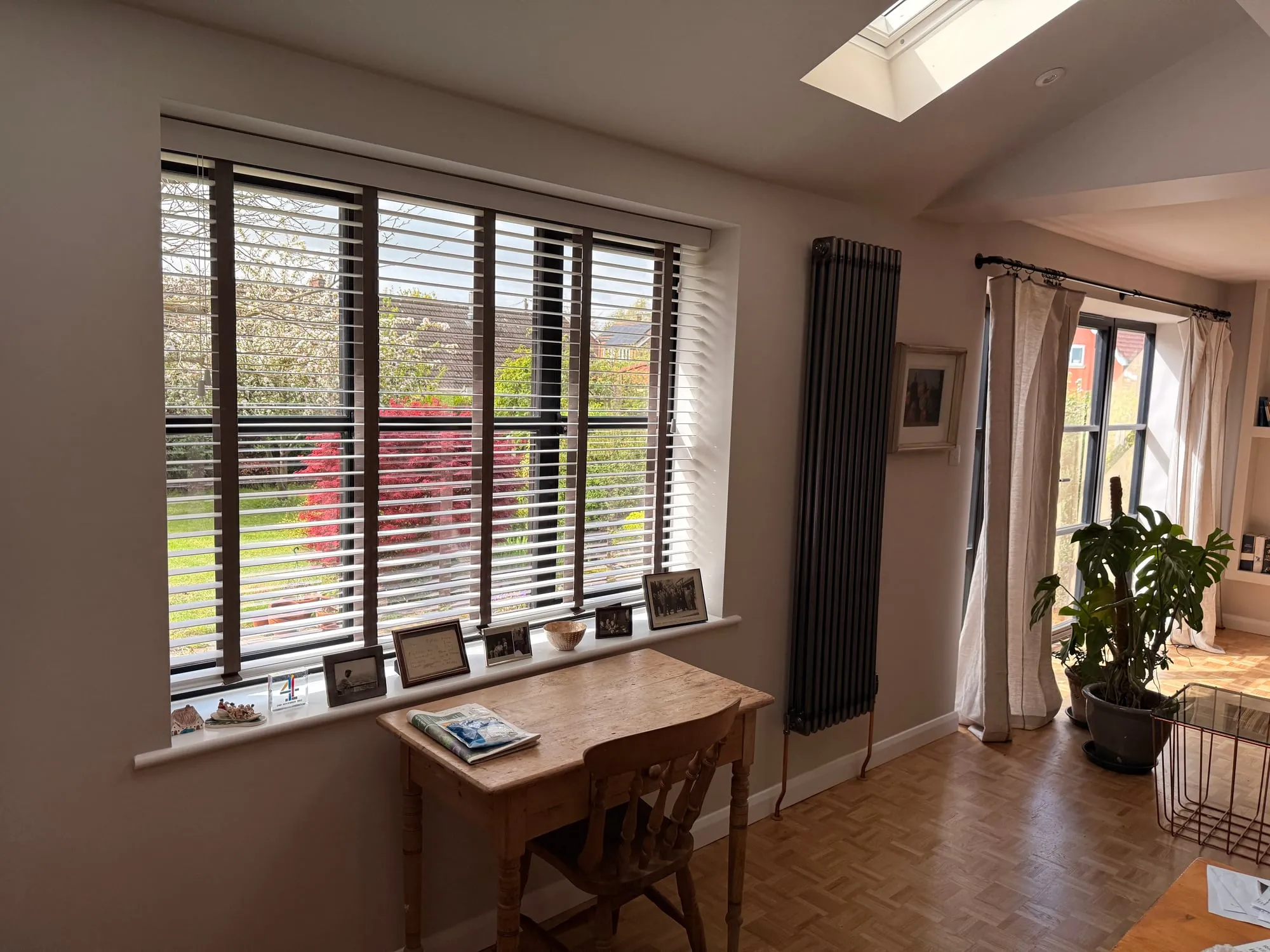 Light wood venetian blinds with brown tape in a Suffolk period dining room with parquet floor, column radiator and skylight